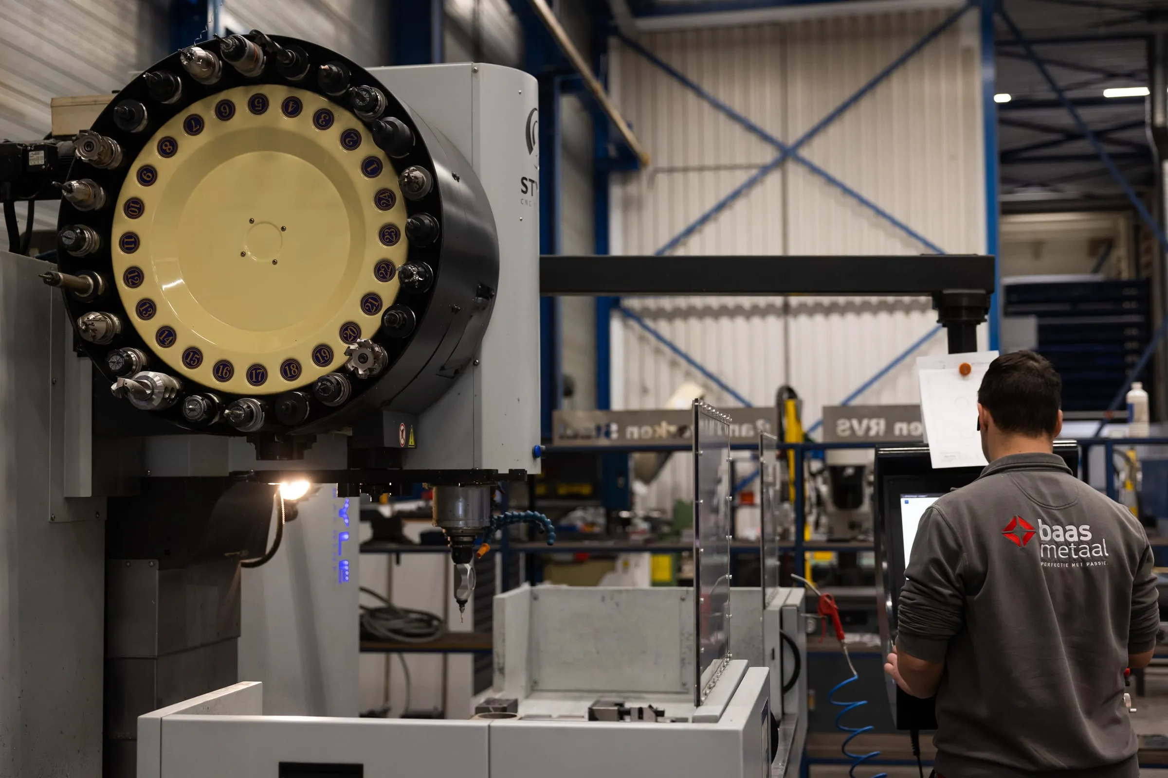 Tool changer of a machining centre, with an employee in the background