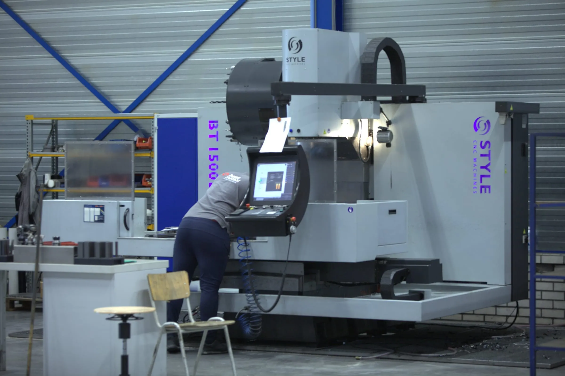 Medewerker aan de besturing van een CNC-bewerkingscentrum in de productiehal