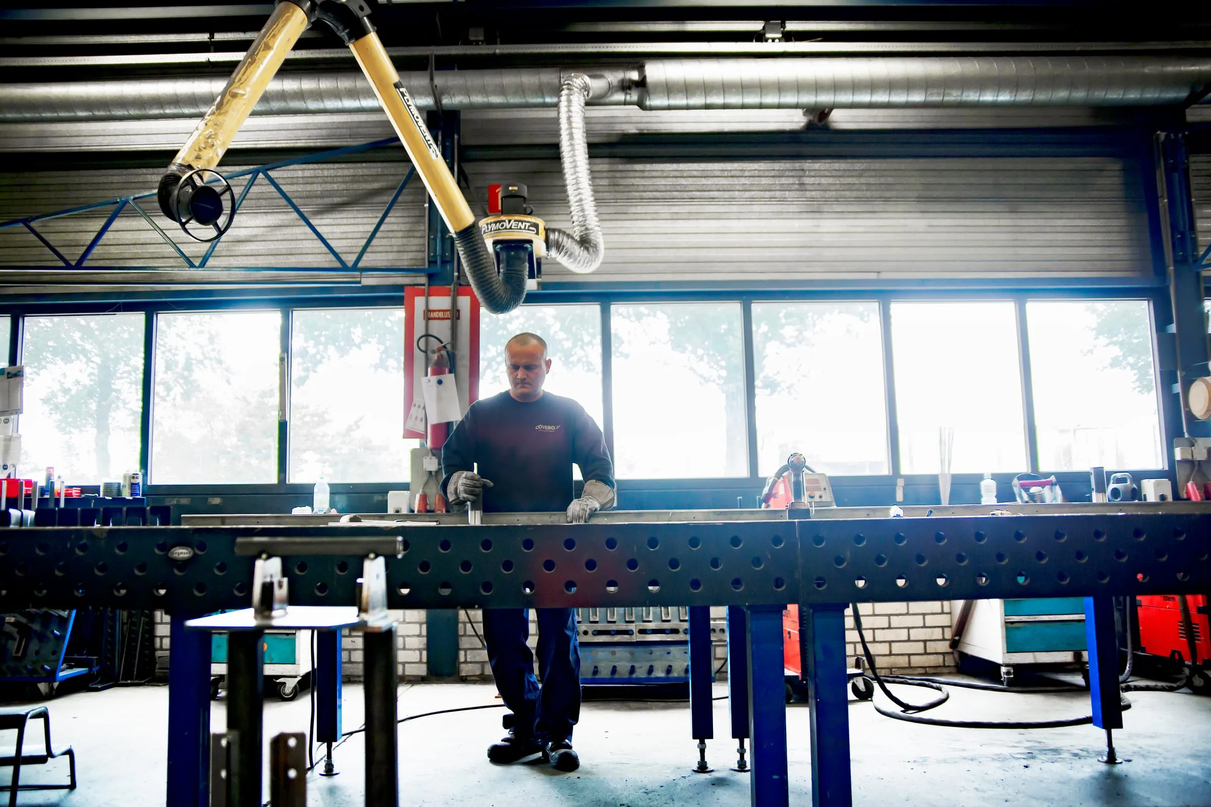Medewerker aan de lastafel in de productiehal
