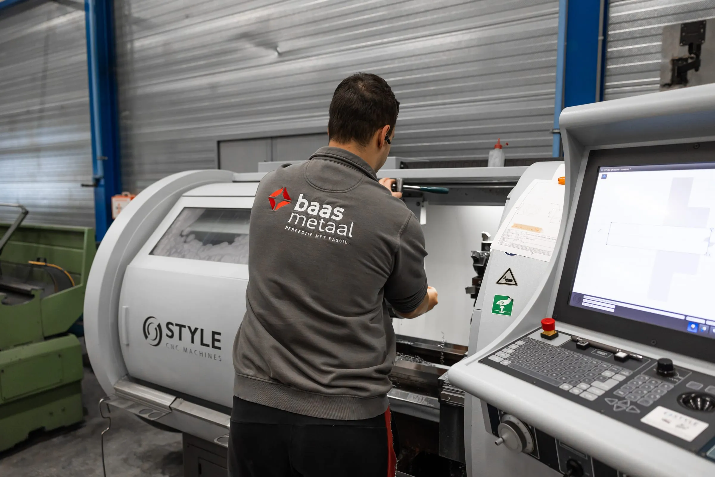 Employee operating the control panel of a CNC machine