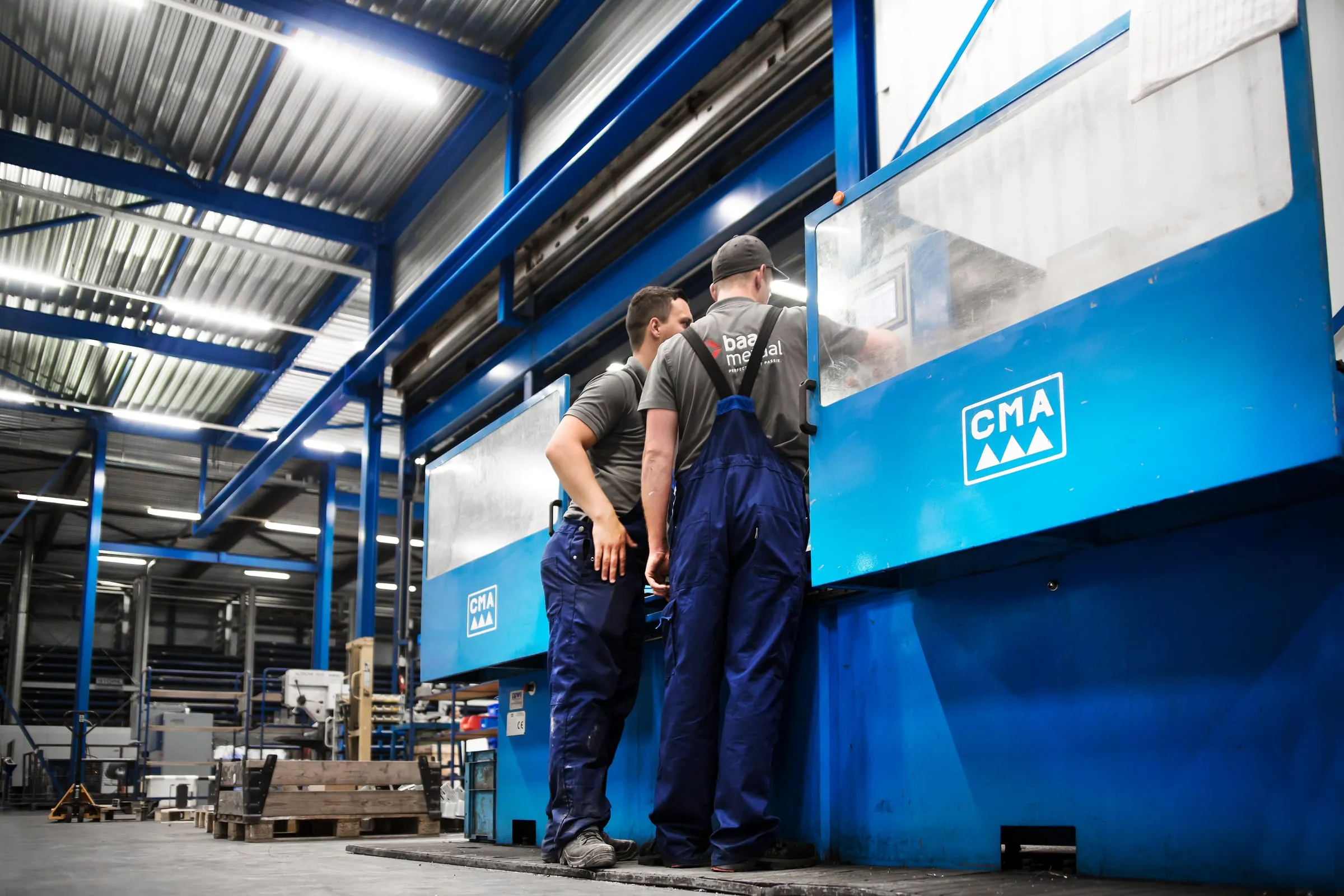 Two Baas Metaal colleagues conferring at a machine