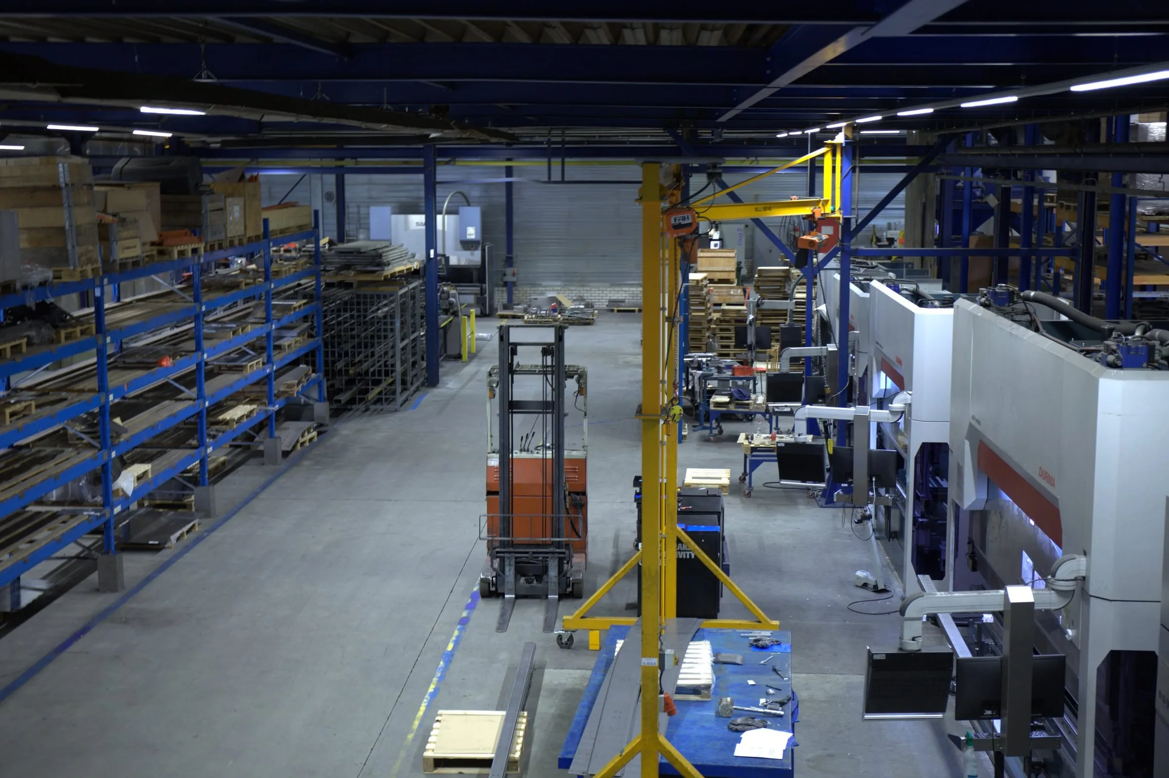 Blick von oben über die Produktionshalle, mit der Reihe Abkantpressen und den Materialregalen